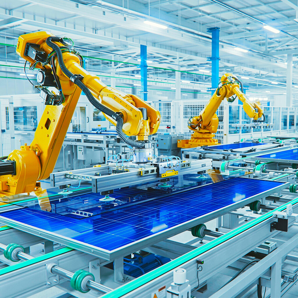 Industria altamente automatizzata, delle braccia robot lavorano su dei pannelli fotovoltaici