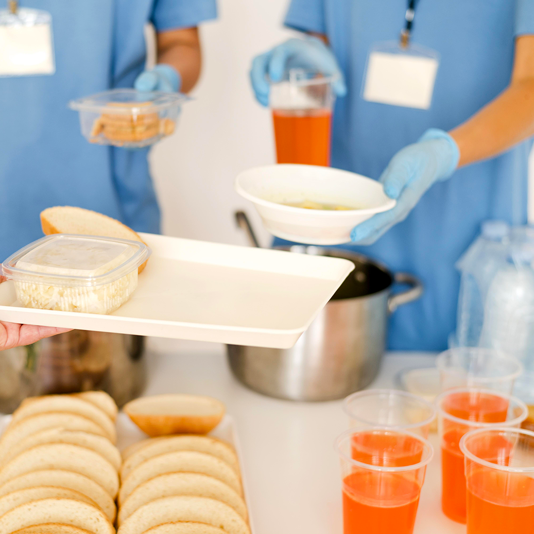 zoom su persone che lavorano in una mensa e distribuiscono il cibo e bevande colorati