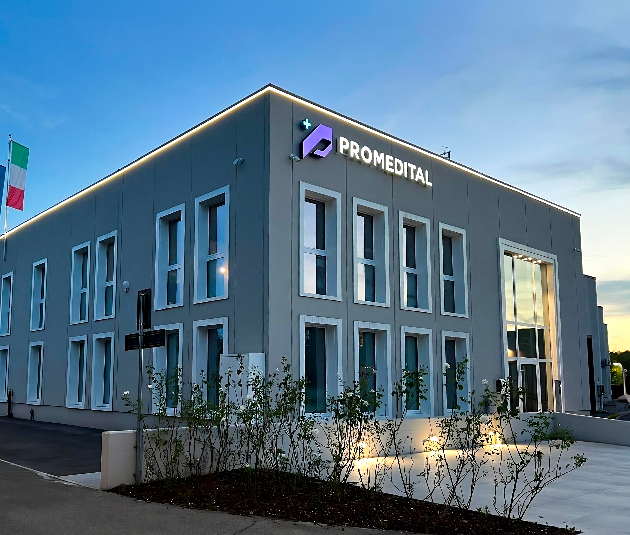 Foto della sede di Promedital. Inquadratura della facciata scattata alla luce del tramonto.
