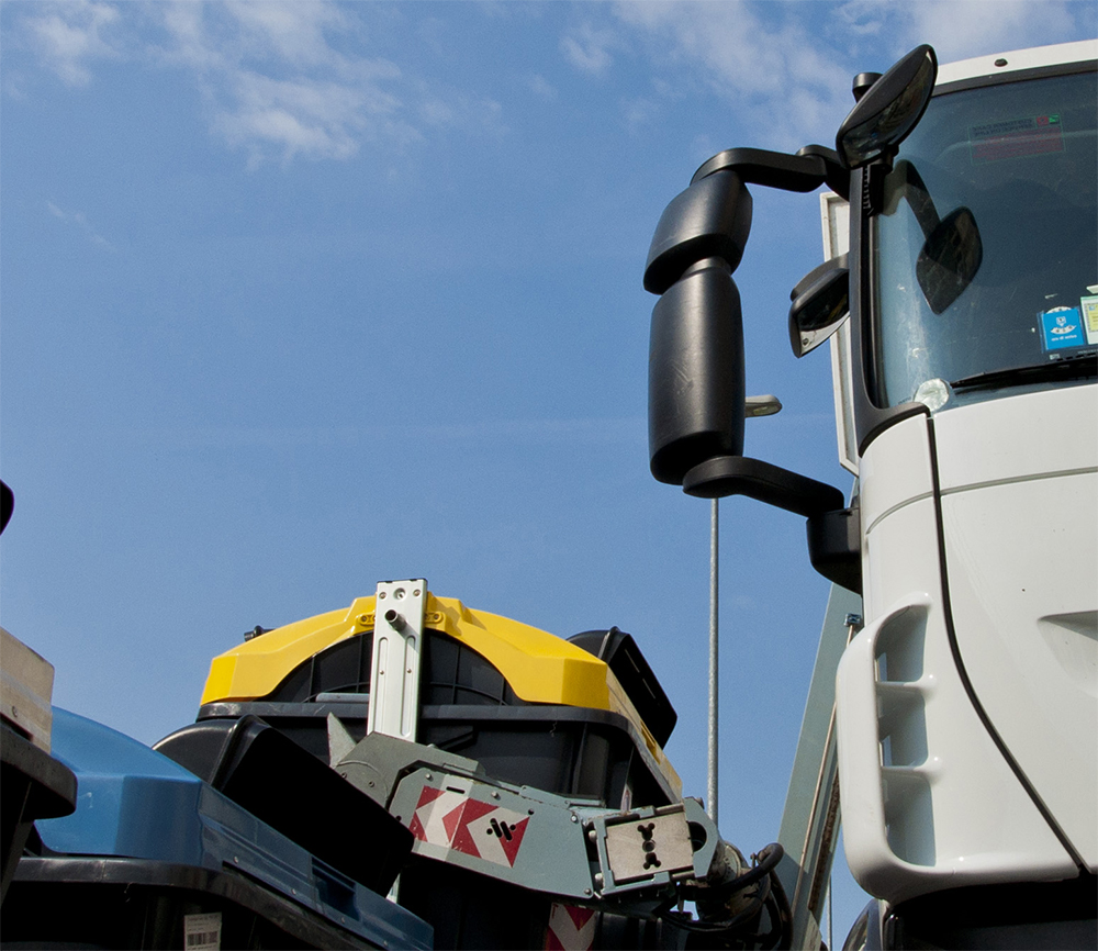Camion della spazzatura vicino a cassonetto
